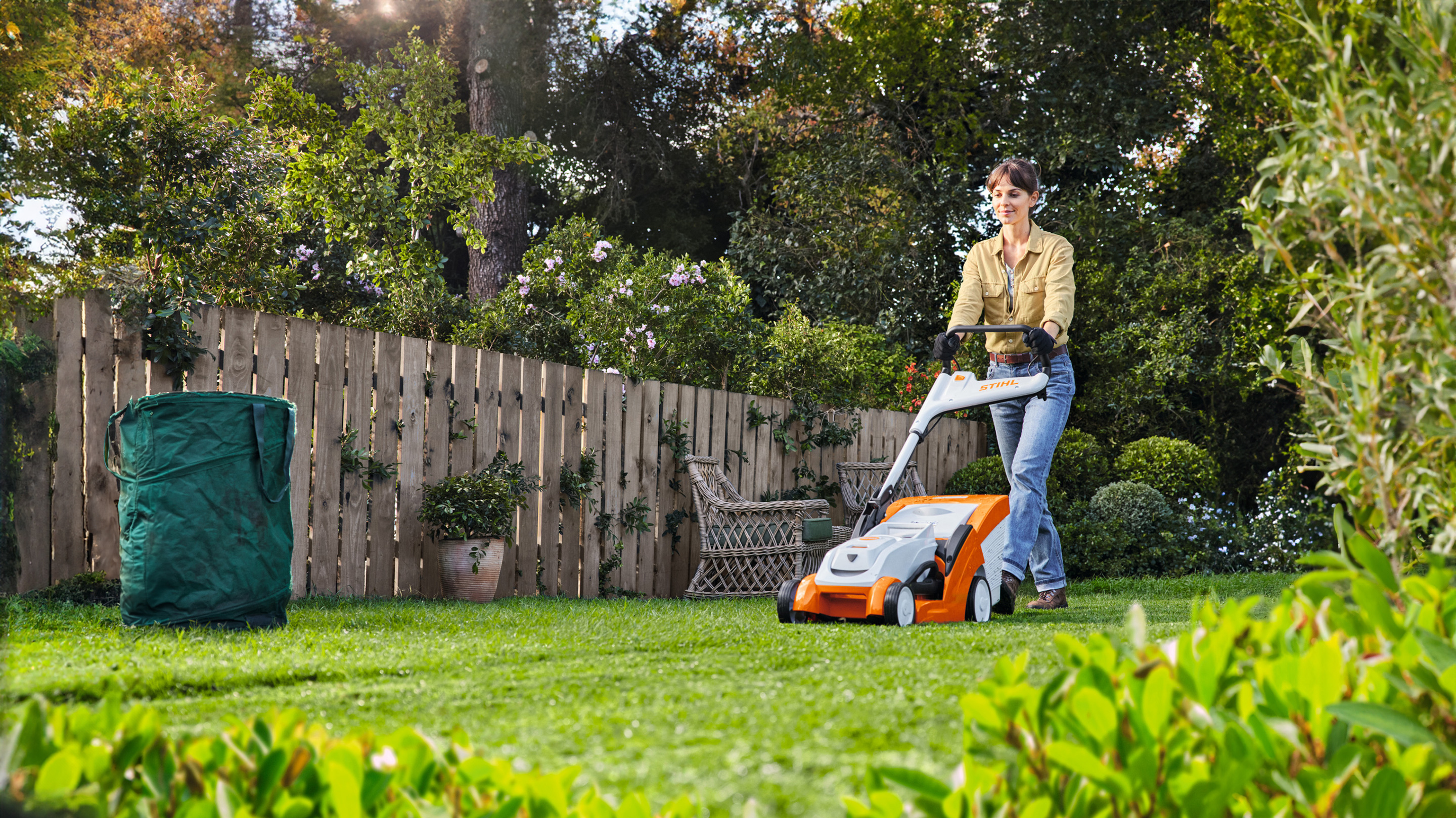 Una donna che falcia il prato con il tosaerba a batteria STIHL RMA 239 C