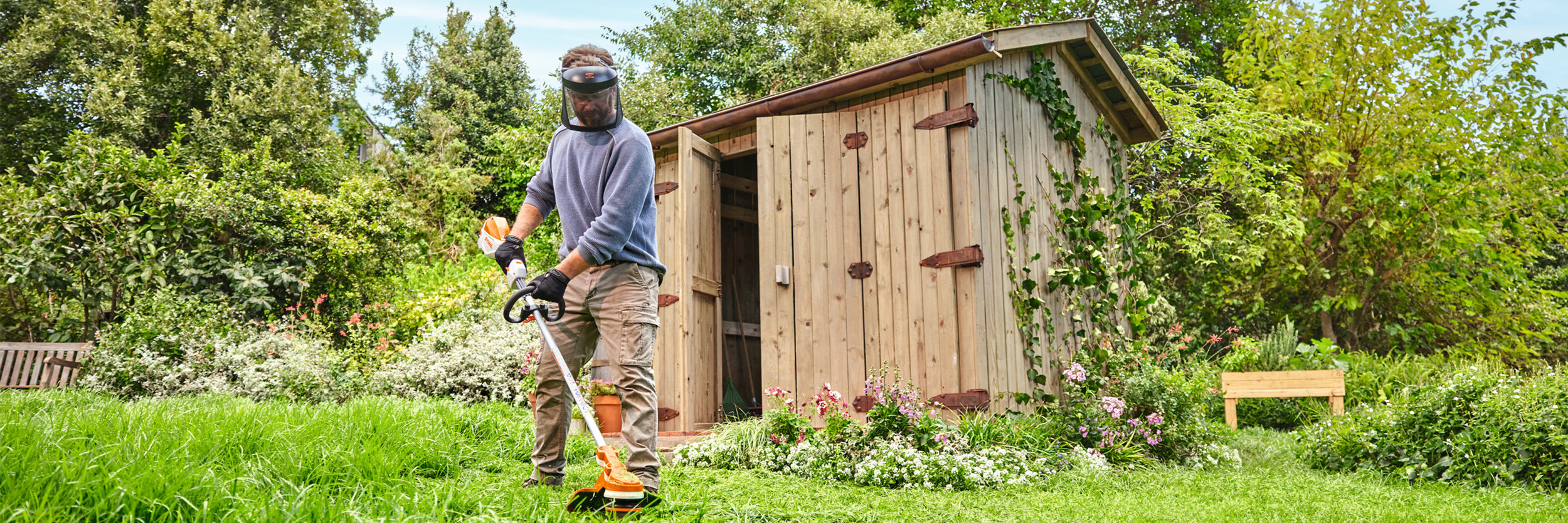  Un uomo taglia l'erba con il decespugliatore a batteria STIHL FSA 70 R