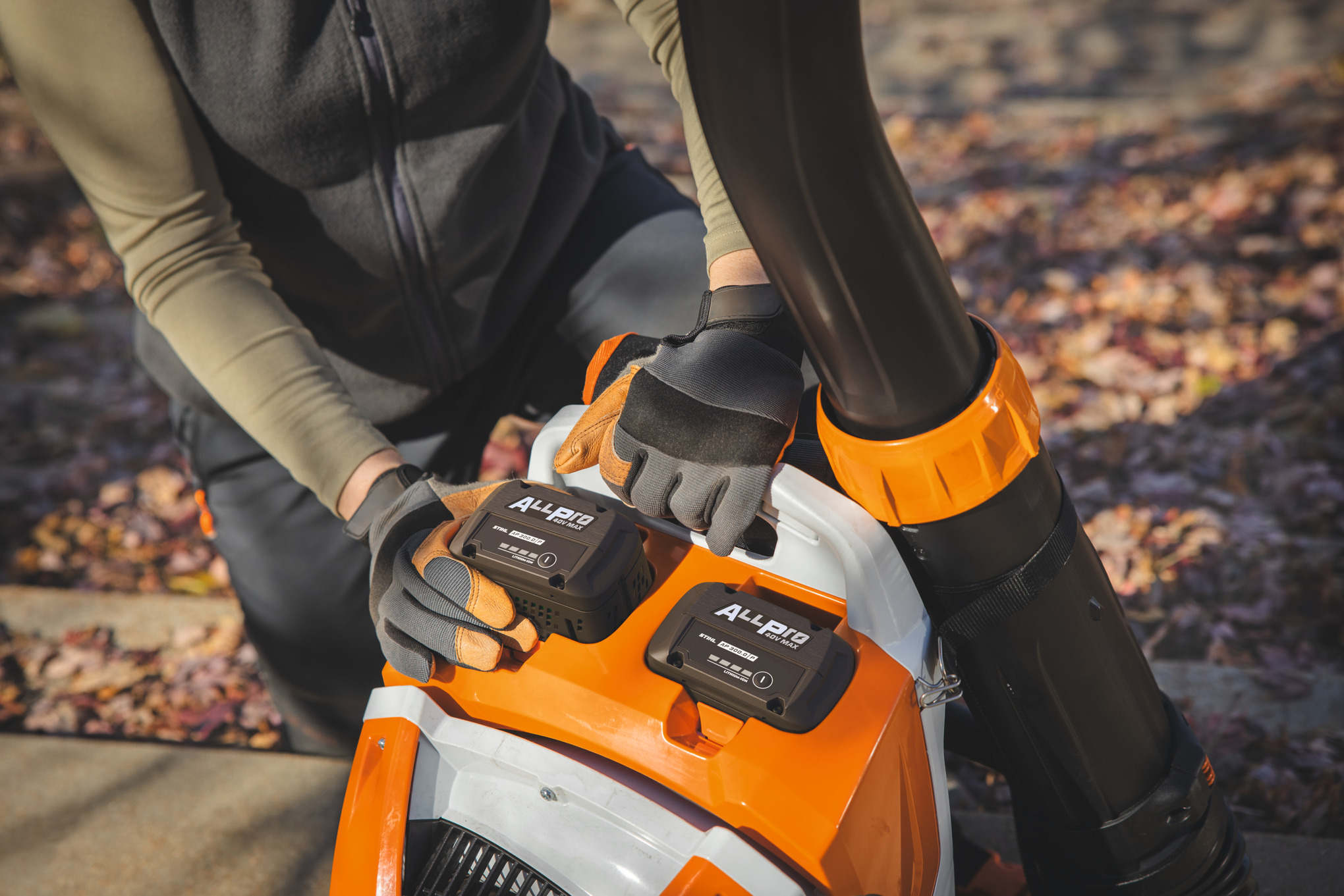 Un giardiniere professionista inserisce la seconda batteria STIHL AP 300.0 P nel soffiatore a zaino a batteria STIHL