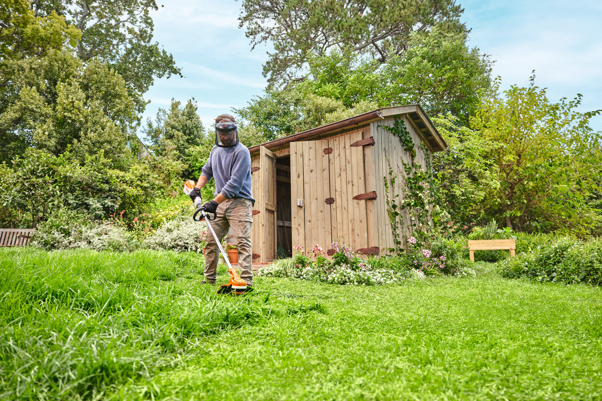  Un uomo taglia l'erba con il decespugliatore a batteria STIHL FSA 70 R