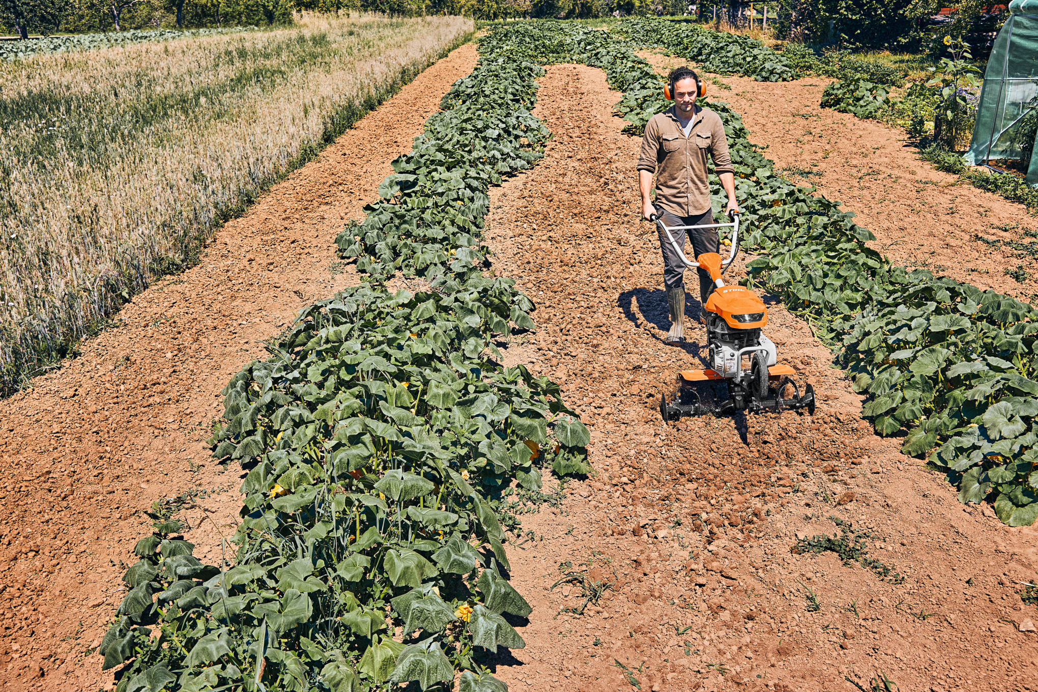 Man using earth auger in a field