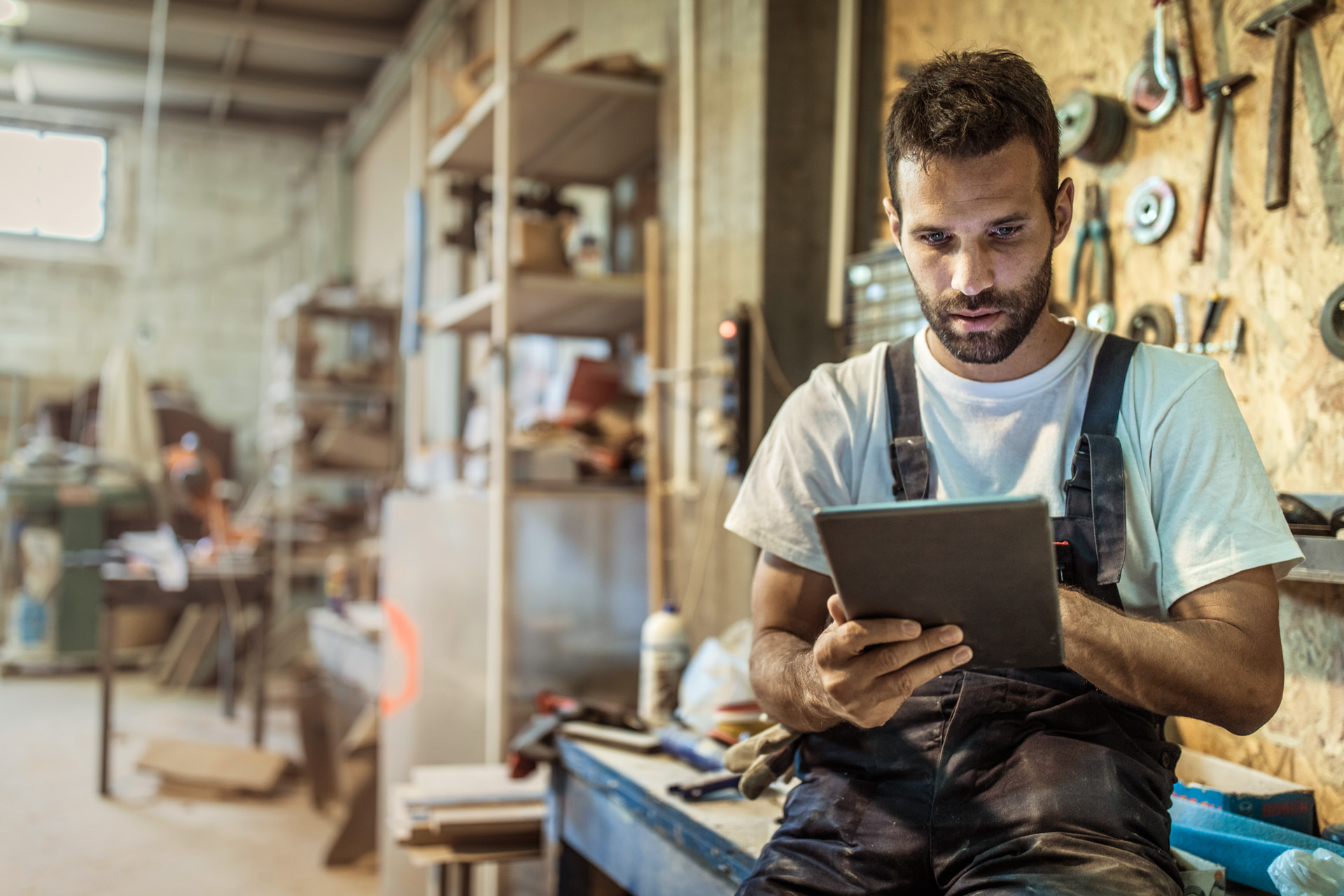 Un uomo in officina usa il consulente di prodotto STIHL su un tablet