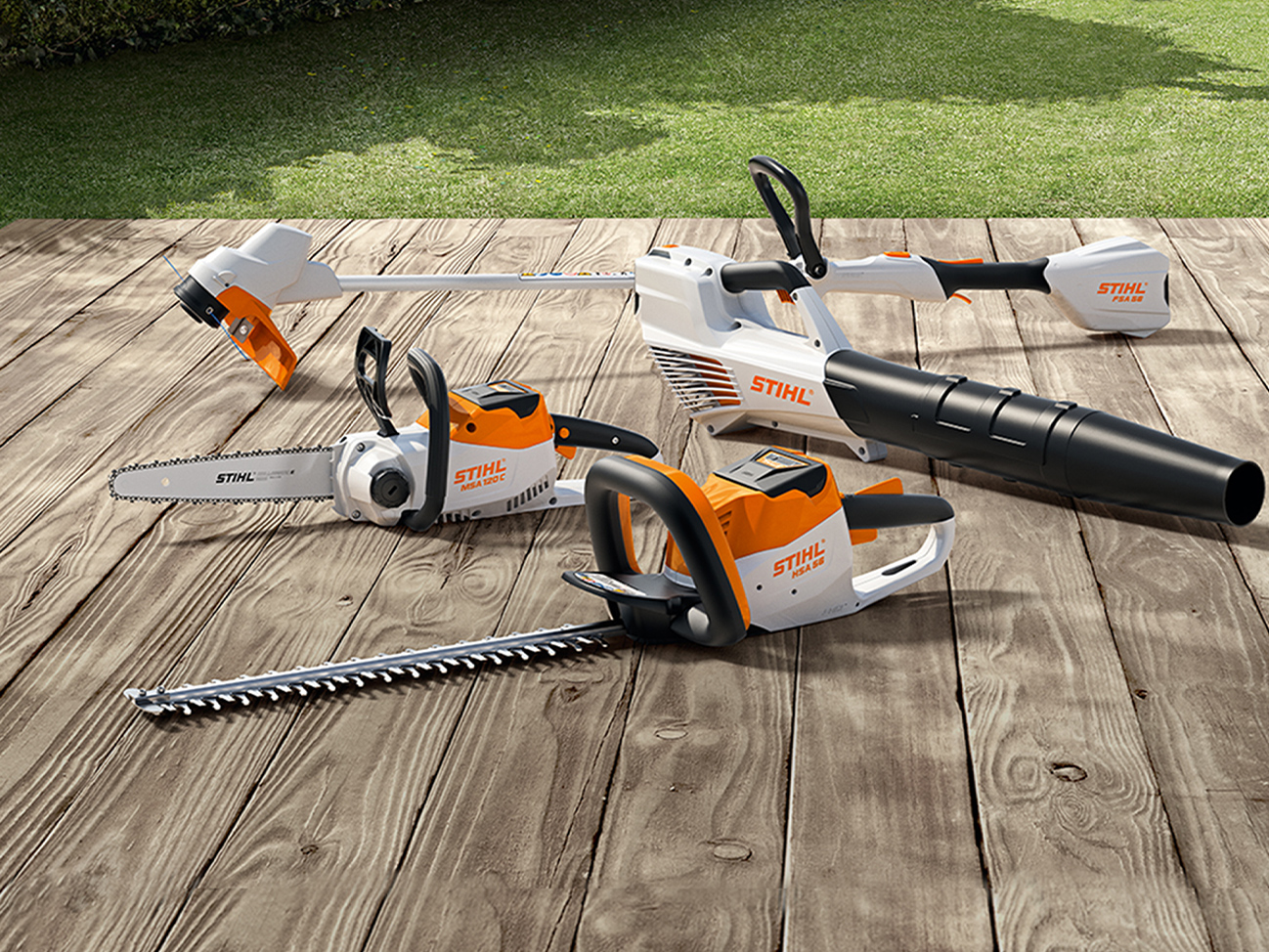 Seghetta a batteria STIHL MSA 120 C, decespugliatore a batteria FSA 57, tagliasiepi a batteria HSA 56, soffiatore a batteria BGA 56 su terrazza in legno