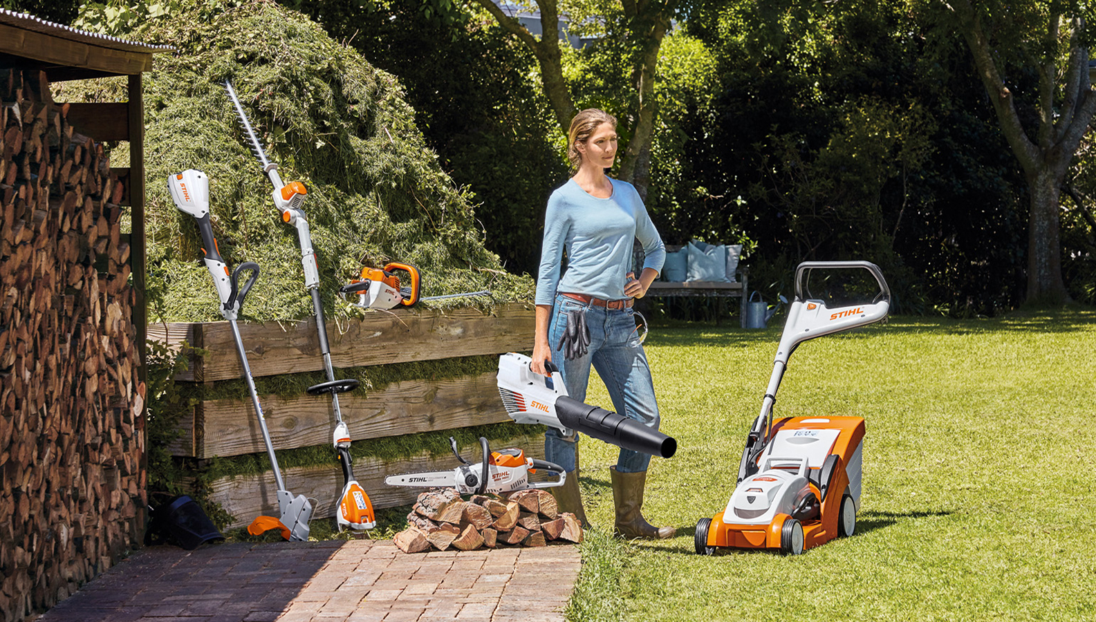 Donna in giardino con una selezione di prodotti a batteria STIHL