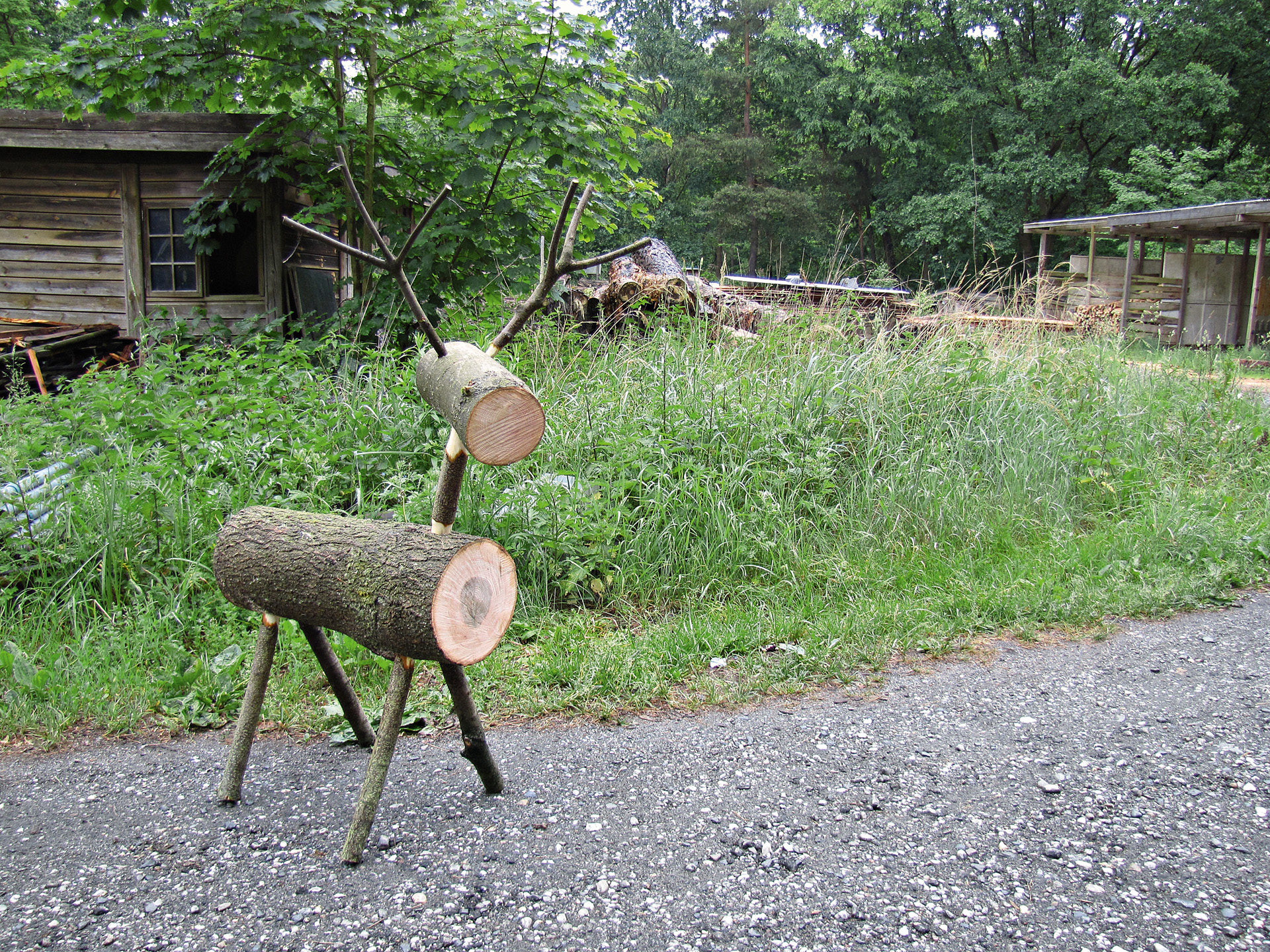 Renna di legno davanti al prato verde e alla capanna di legno