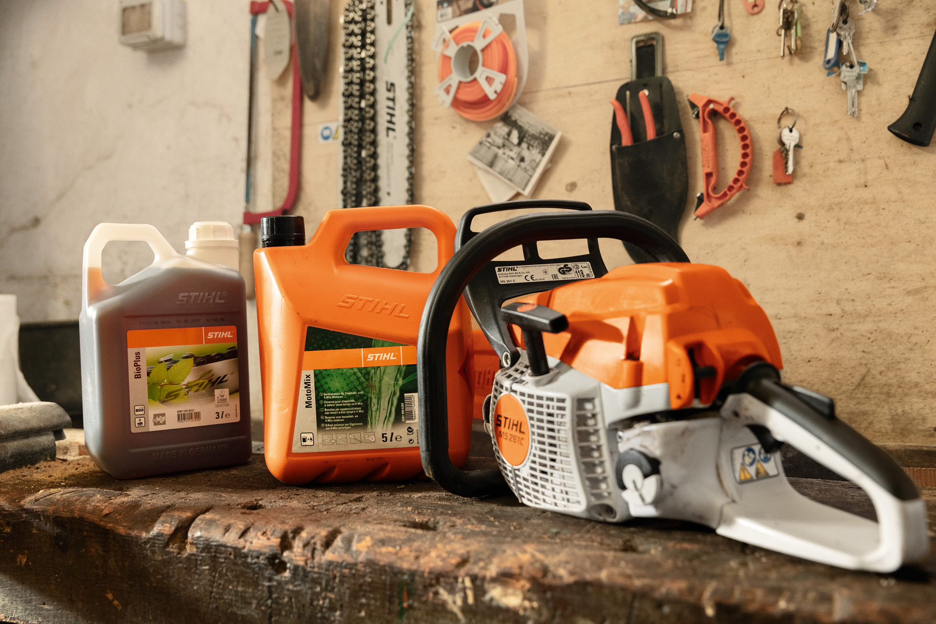 Motosega a benzina STIHL MS 261 C-BE con tappo per serbatoio carburante senza attrezzi accanto a MotoMix e BioPlus