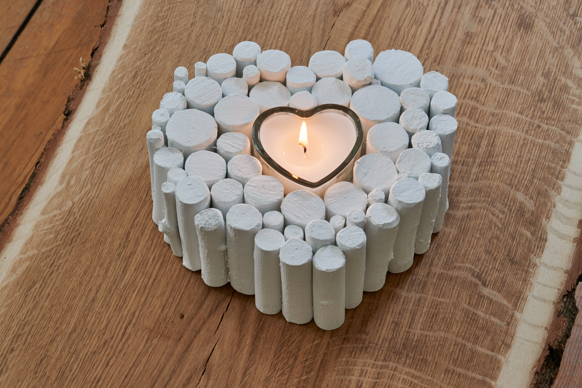 Cuore bianco fatto di rami con candela accesa come regalo per San Valentino