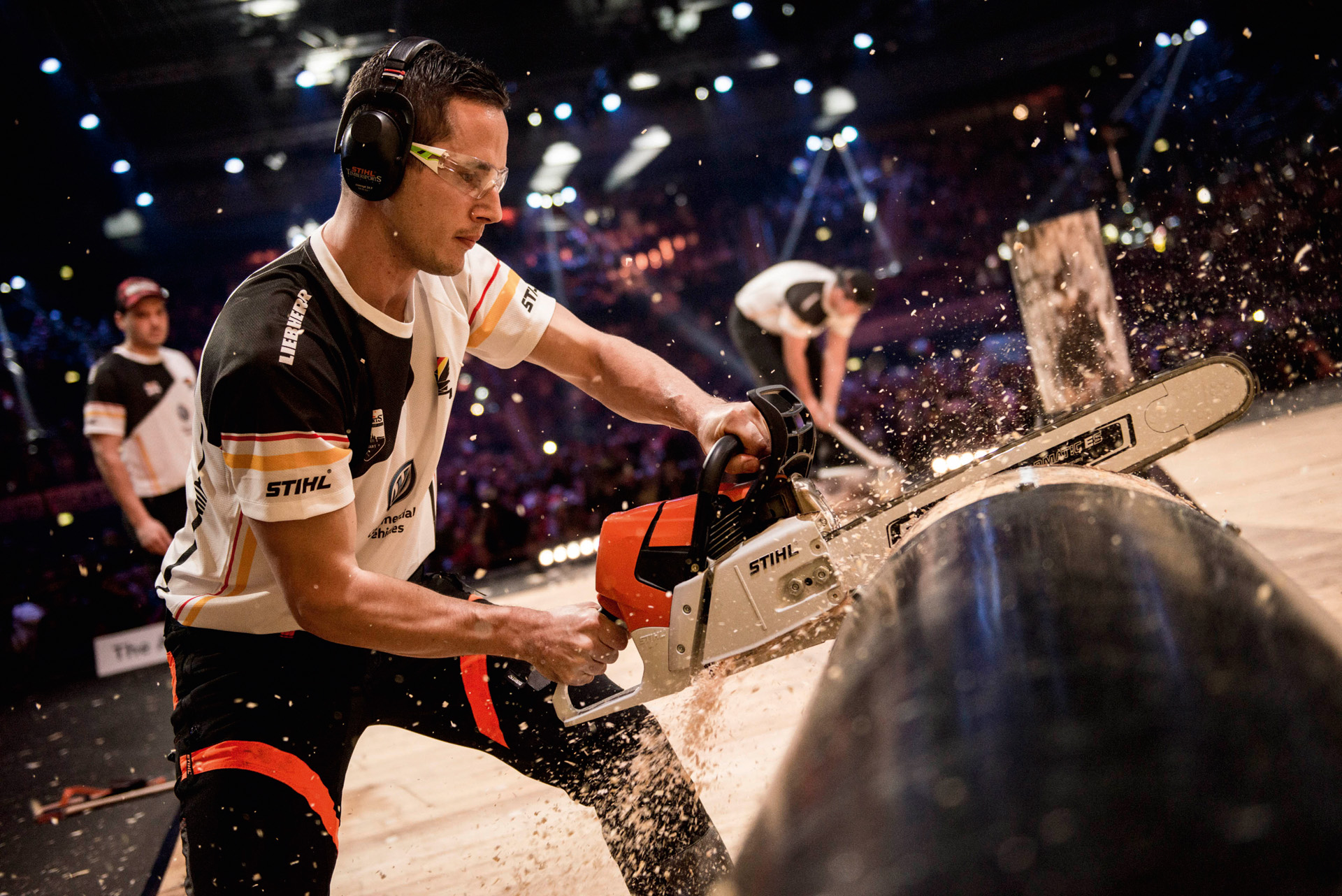 Atleta STIHL TIMBERSPORTS® sega un tronco d'albero durante una competizione 