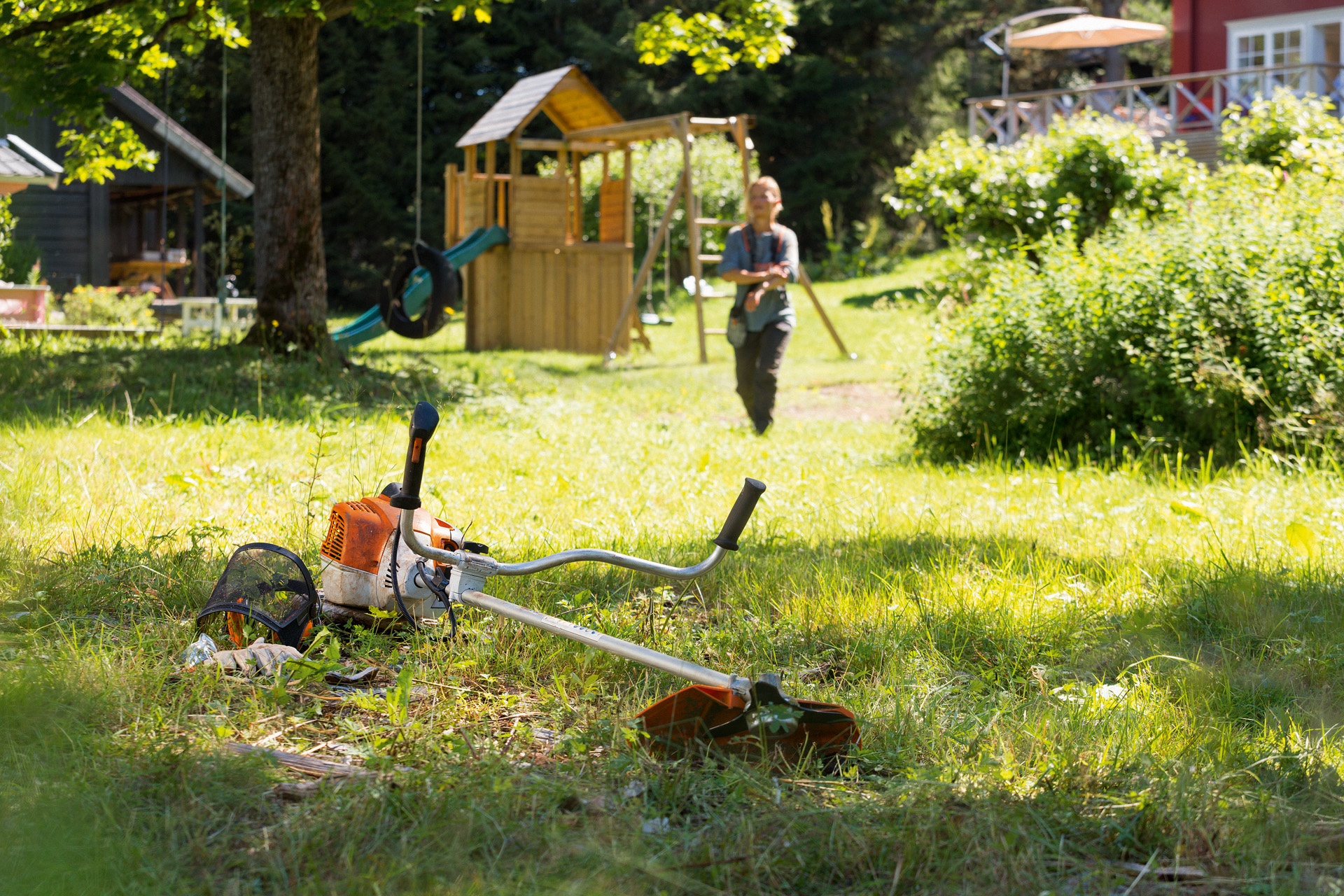 Decespugliatore STIHL FS 240 adagiato sull'erba, sullo sfondo un uomo si prepara per la manutenzione