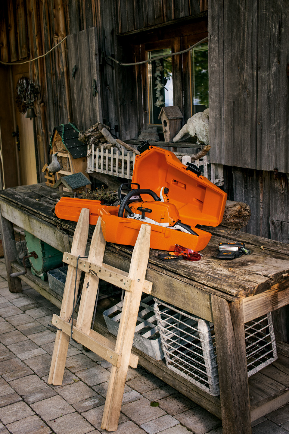 Motosega STIHL all'interno di una custodia su un banco da lavoro in legno accanto agli accessori