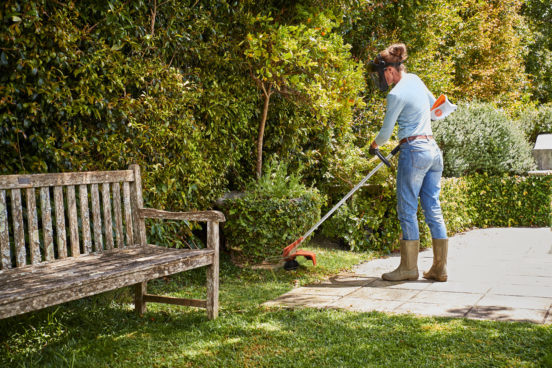 Donna che falcia il prato e i bordi con il rifinitore a batteria FSA 60 R STIHL