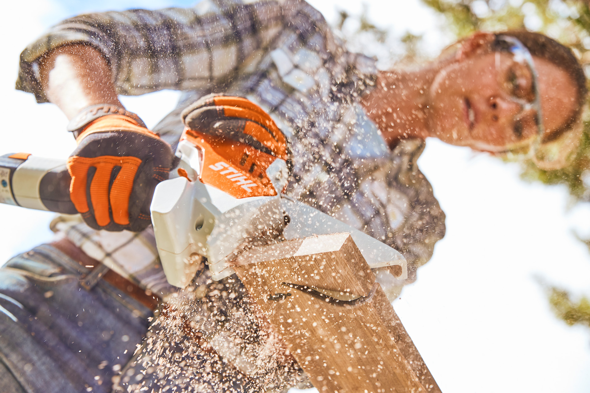 Donna sega una tavola di legno con una sega STIHL