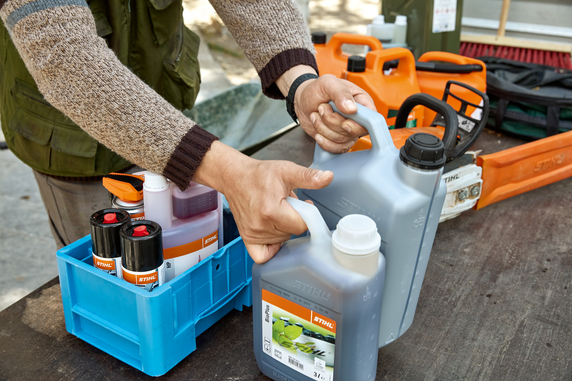 Una persona che sistema i carburanti e lubrificanti STIHL in casse per il trasporto