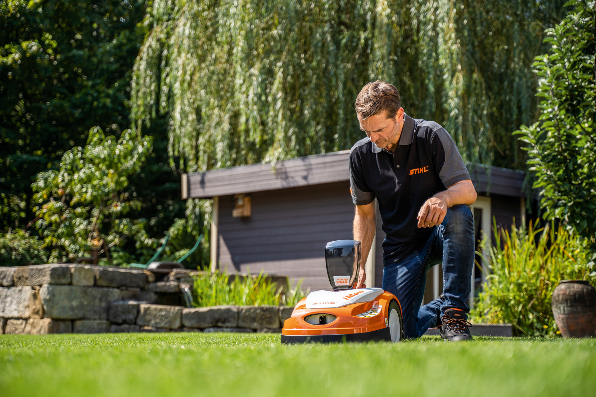 Il rivenditore STIHL programma il programma di taglio di un robot rasaerba STIHL iMOW in un giardino