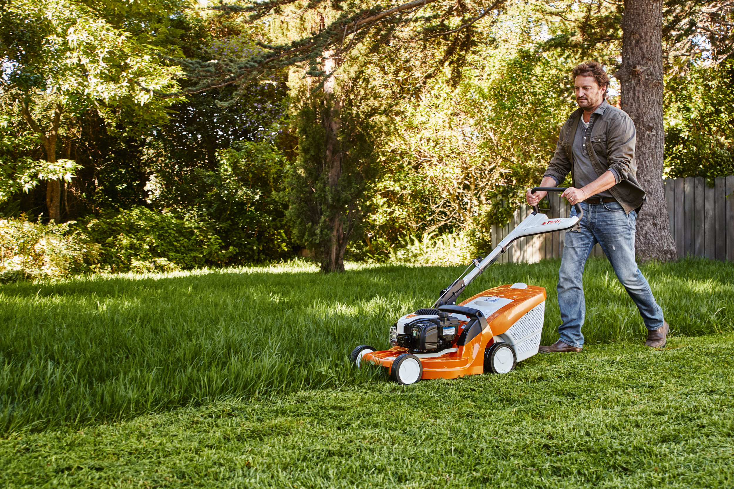 Un uomo taglia il prato in giardino con un tosaerba STIHL 