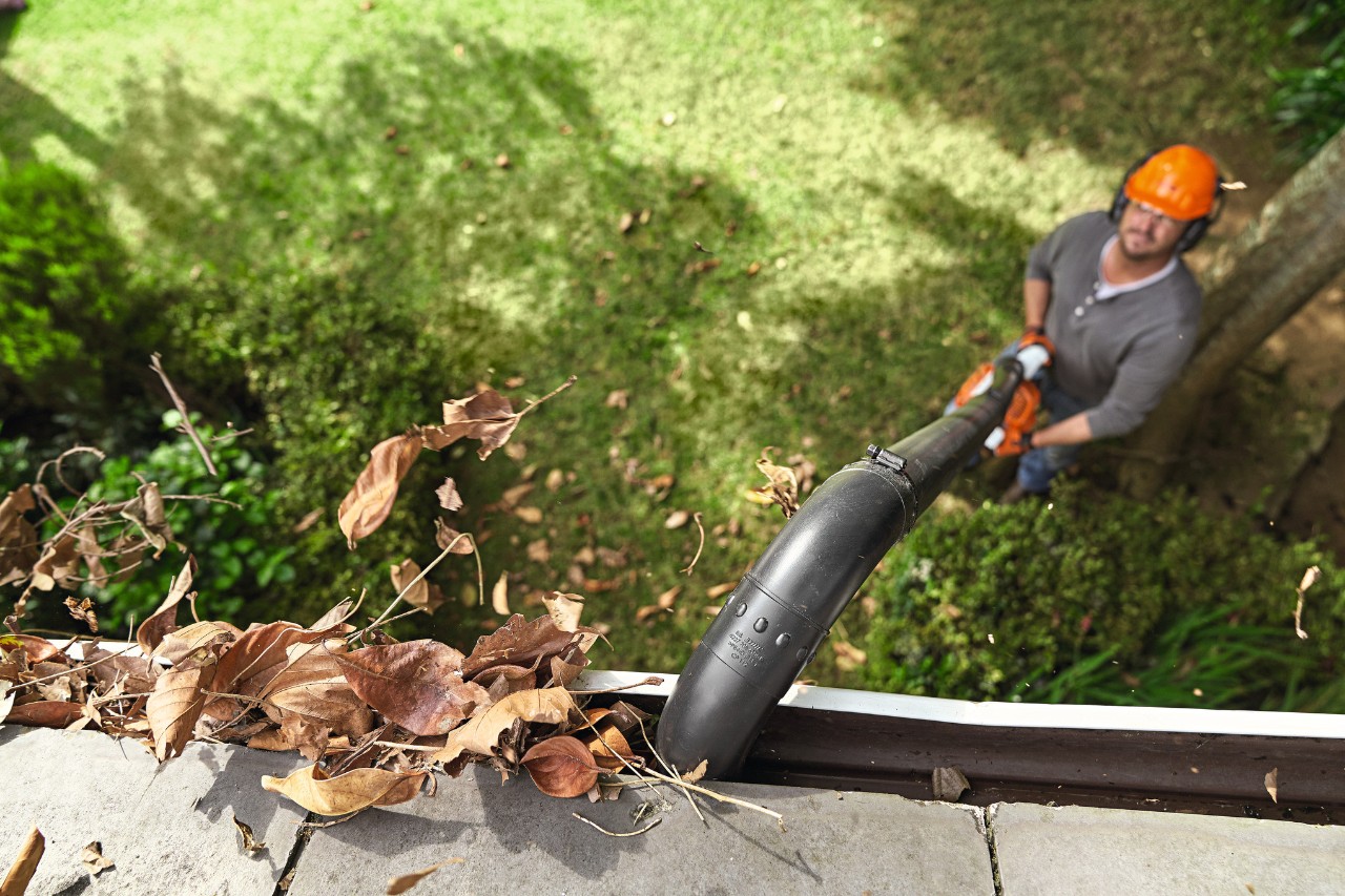 Uomo che pulisce la grondaia con il set per la pulizia delle grondaie di STIHL