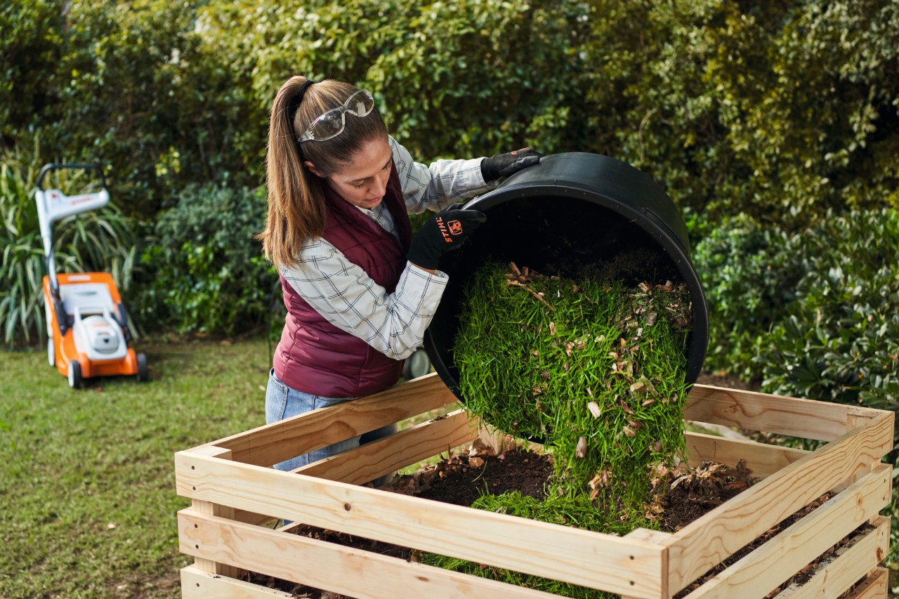 Donna che rovescia il compost in una compostiera