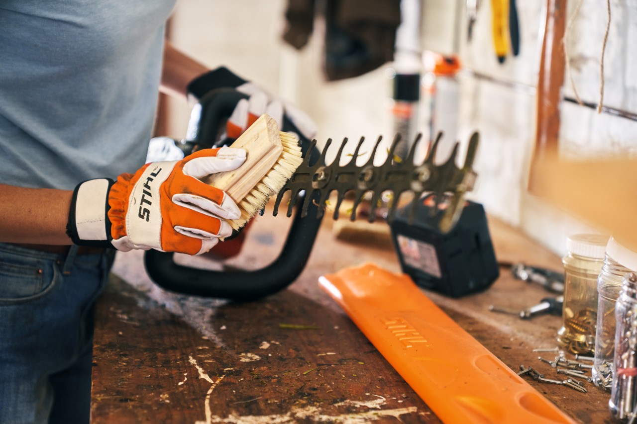Pulizia del tosasiepi a batteria STIHL HSA 56 effettuata con l'ausilio di una spazzola