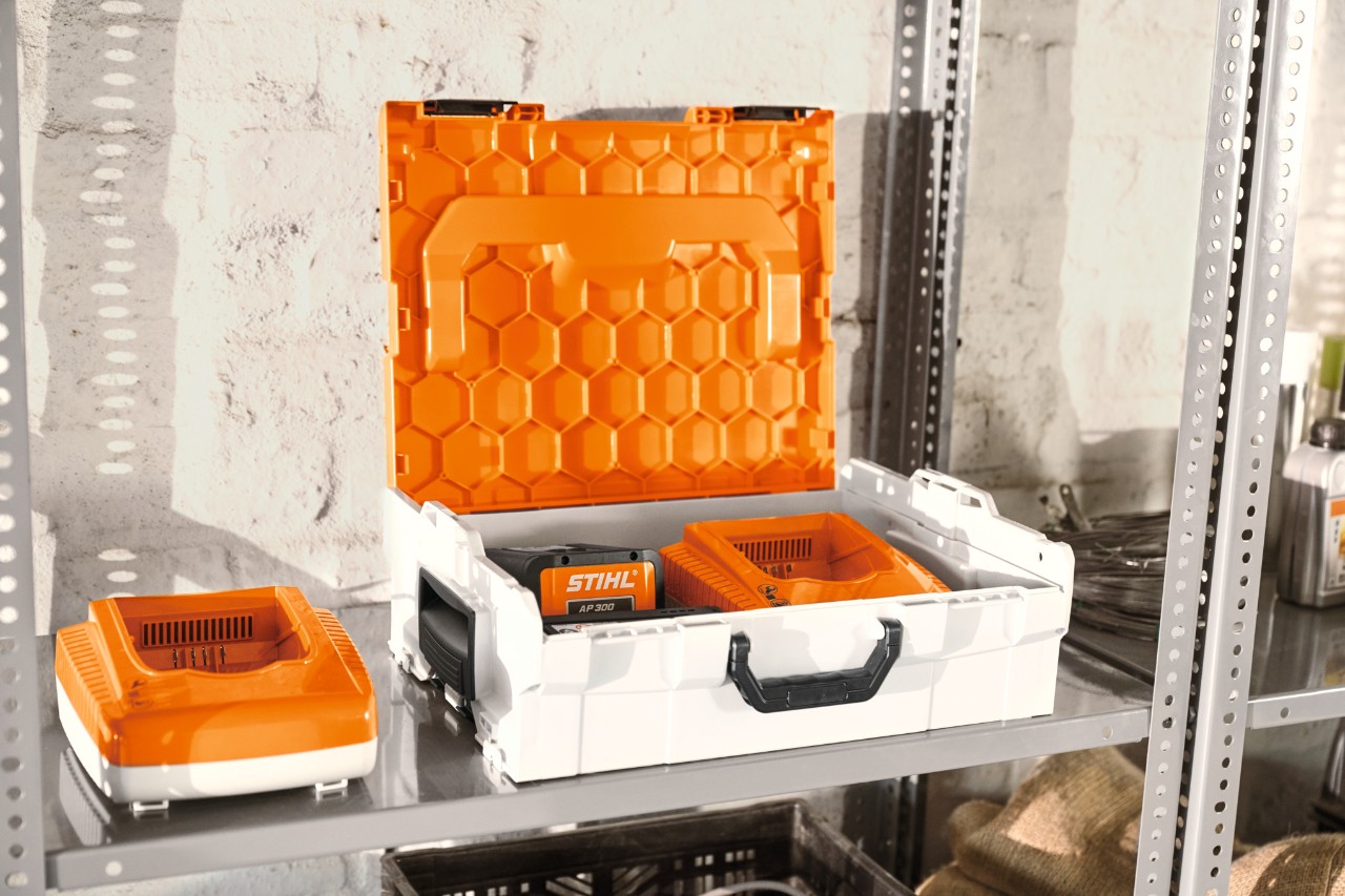 Scatola batteria STIHL con batterie STIHL in uno scaffale di un'officina  